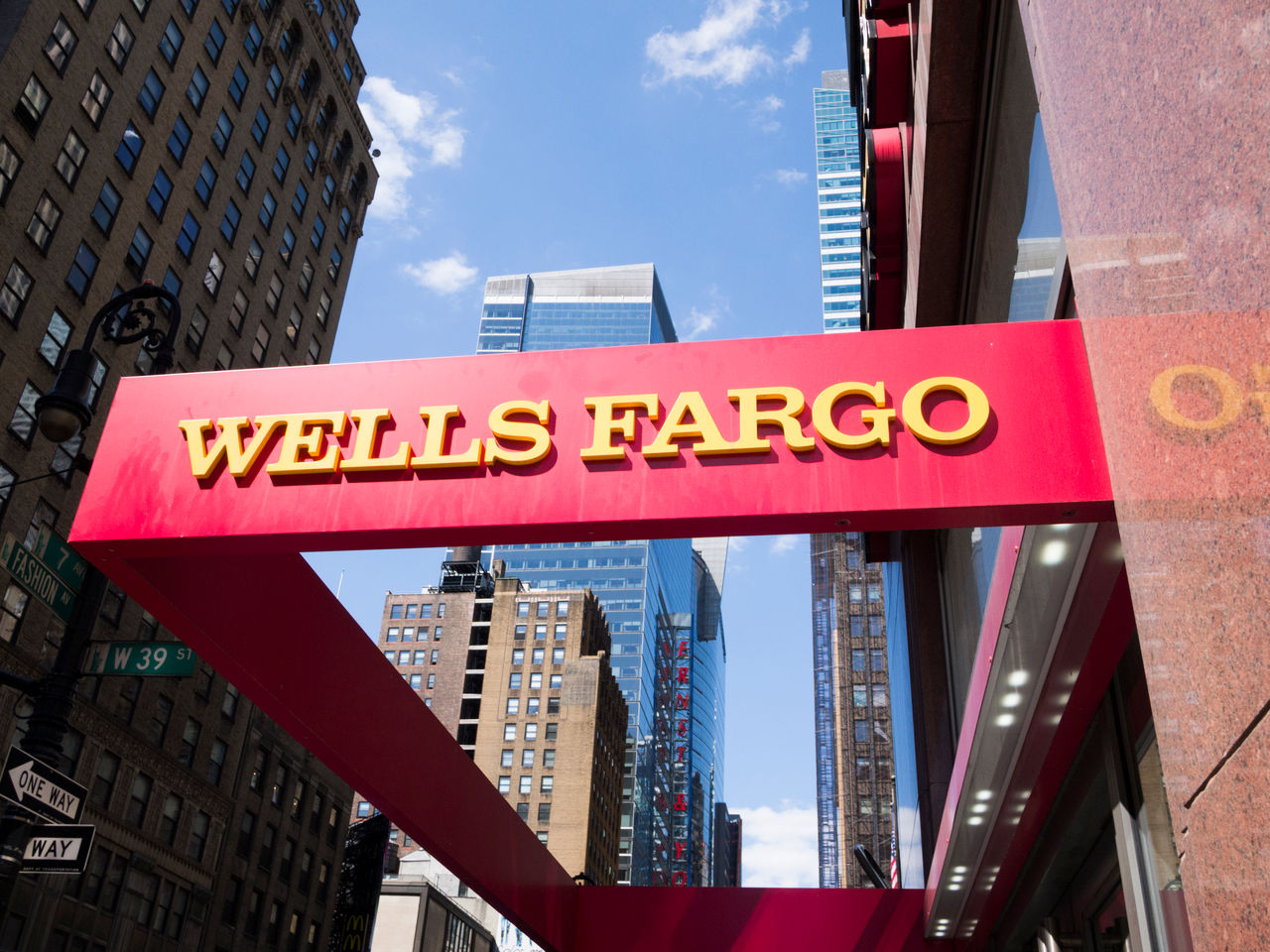 A red and yellow Wells Fargo sign at a Wells Fargo location in Midtown Manhattan.