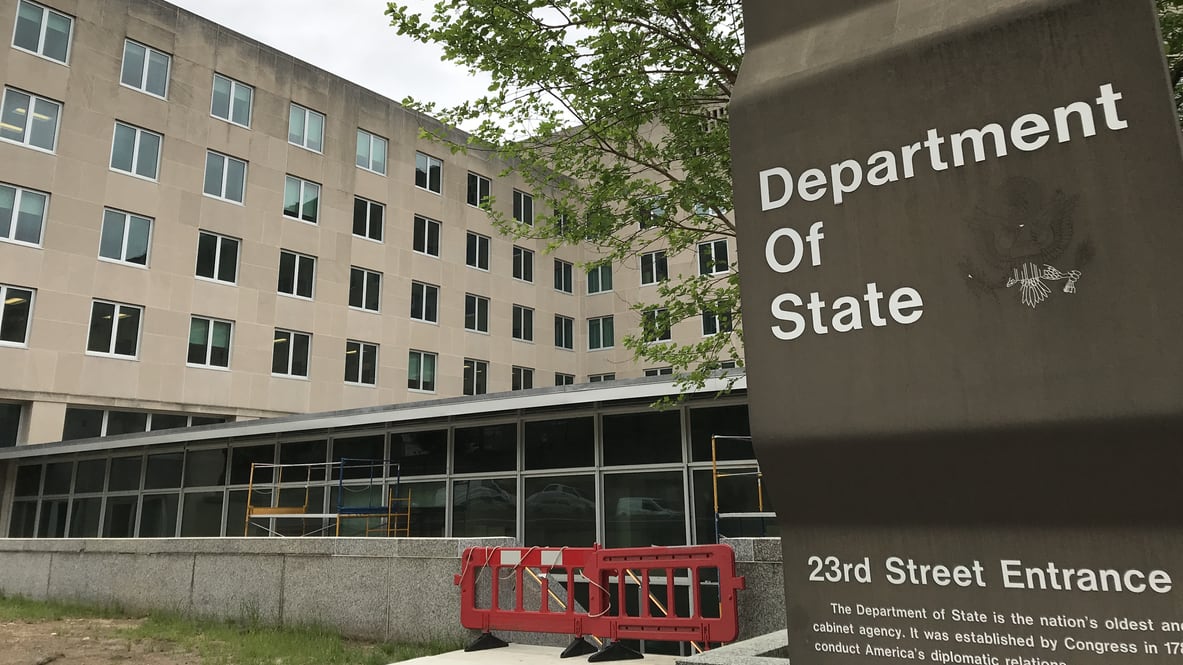 The department of state sign is in front of a building.