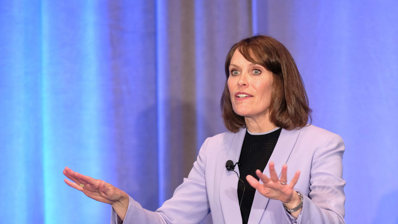 A woman in a suit giving a presentation.