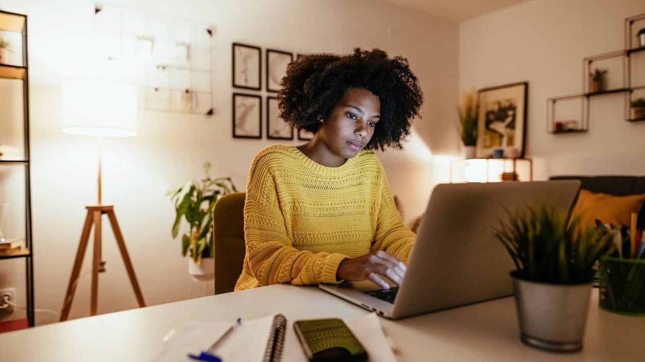 A woman working on her laptop in her home office.