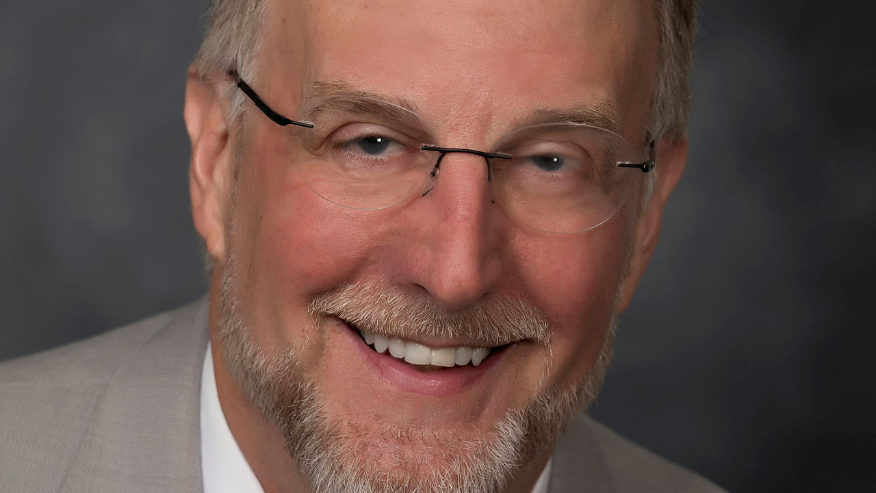 A smiling man in a suit and tie.