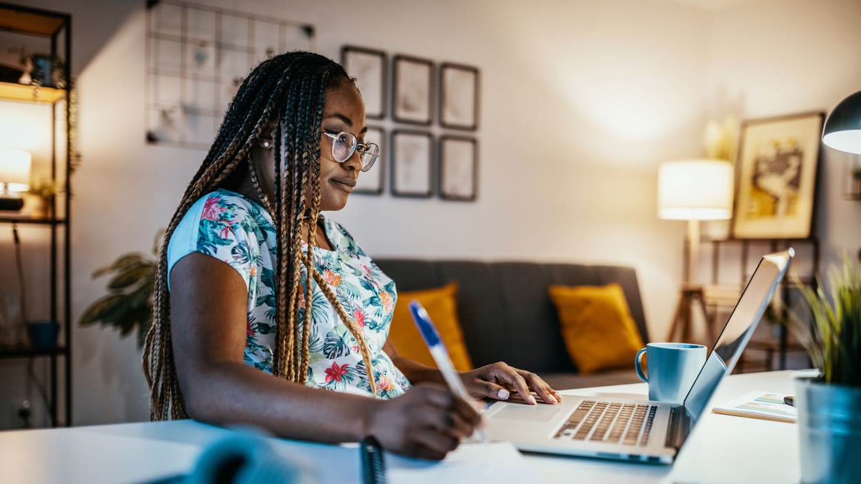 A young woman working on her laptop at home.