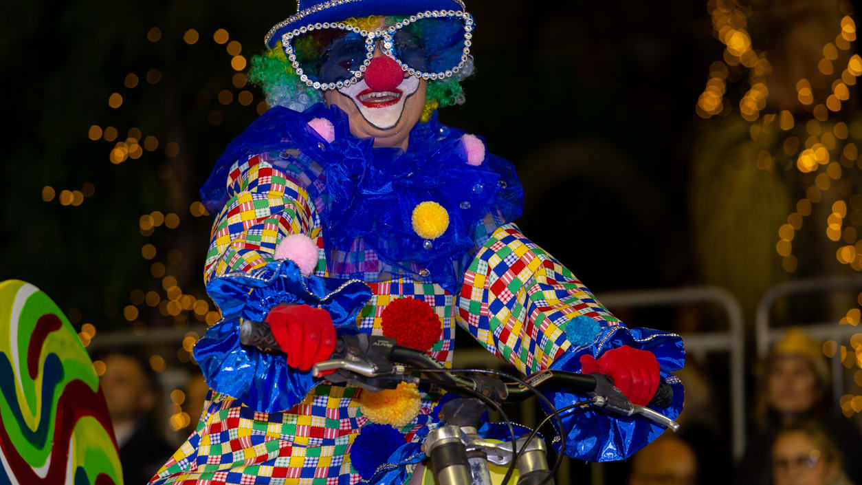 A clown on a bicycle.