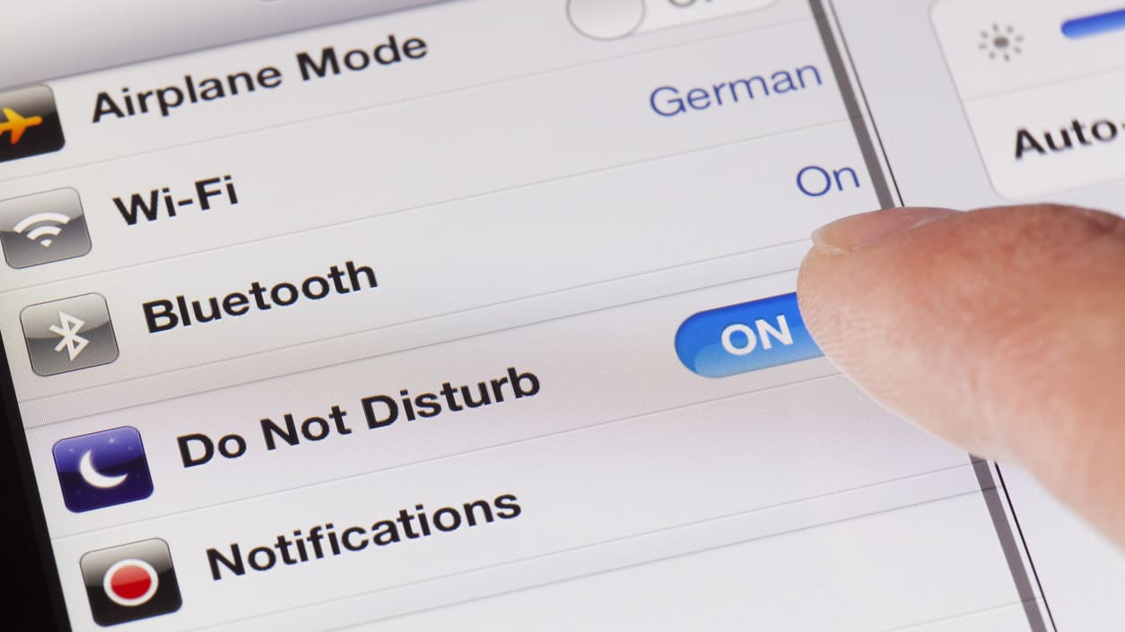 A person pointing at an ipad with an airplane mode on it.
