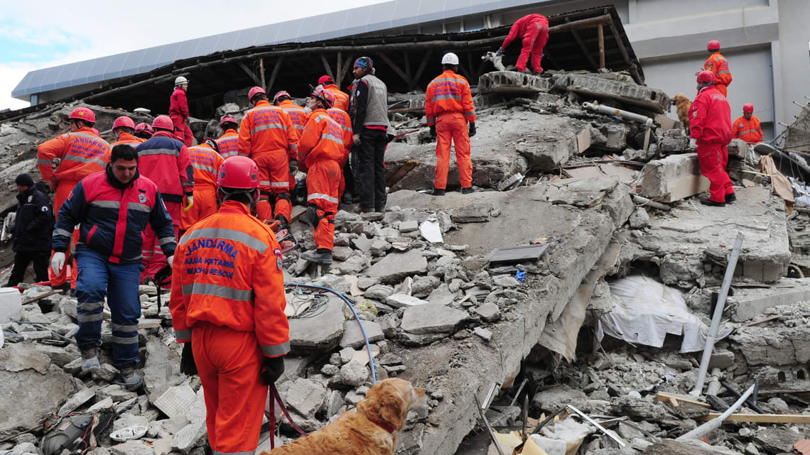 A group of people standing near rubble.