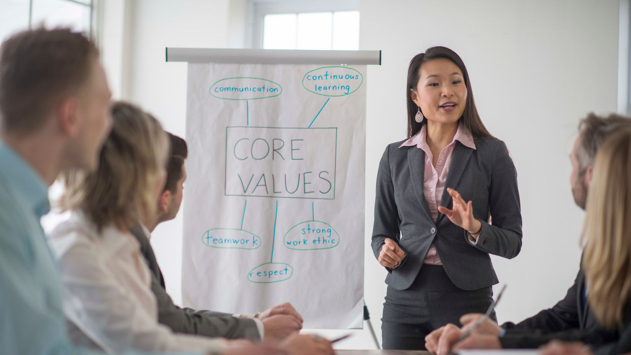 A woman is giving a presentation to a group of business people.