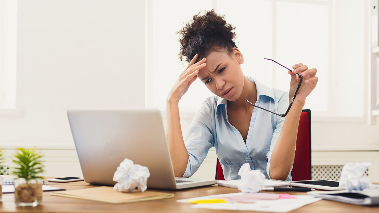 A woman is sitting at a desk with a laptop.