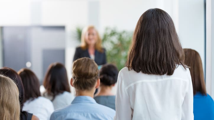 A woman is giving a presentation to a group of people.