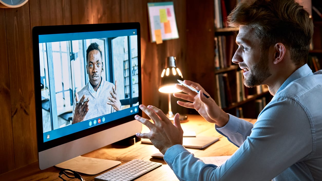 A man is using a computer to make a video call.