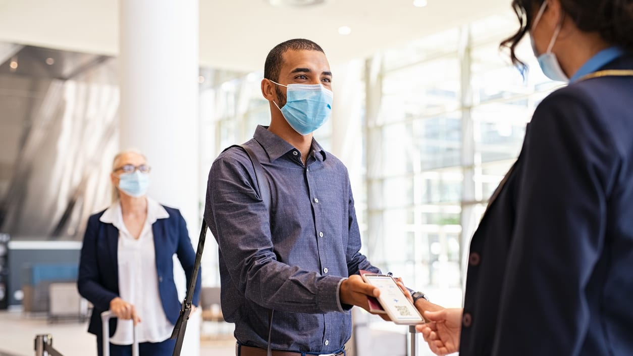 A group of people wearing face masks at an airport.