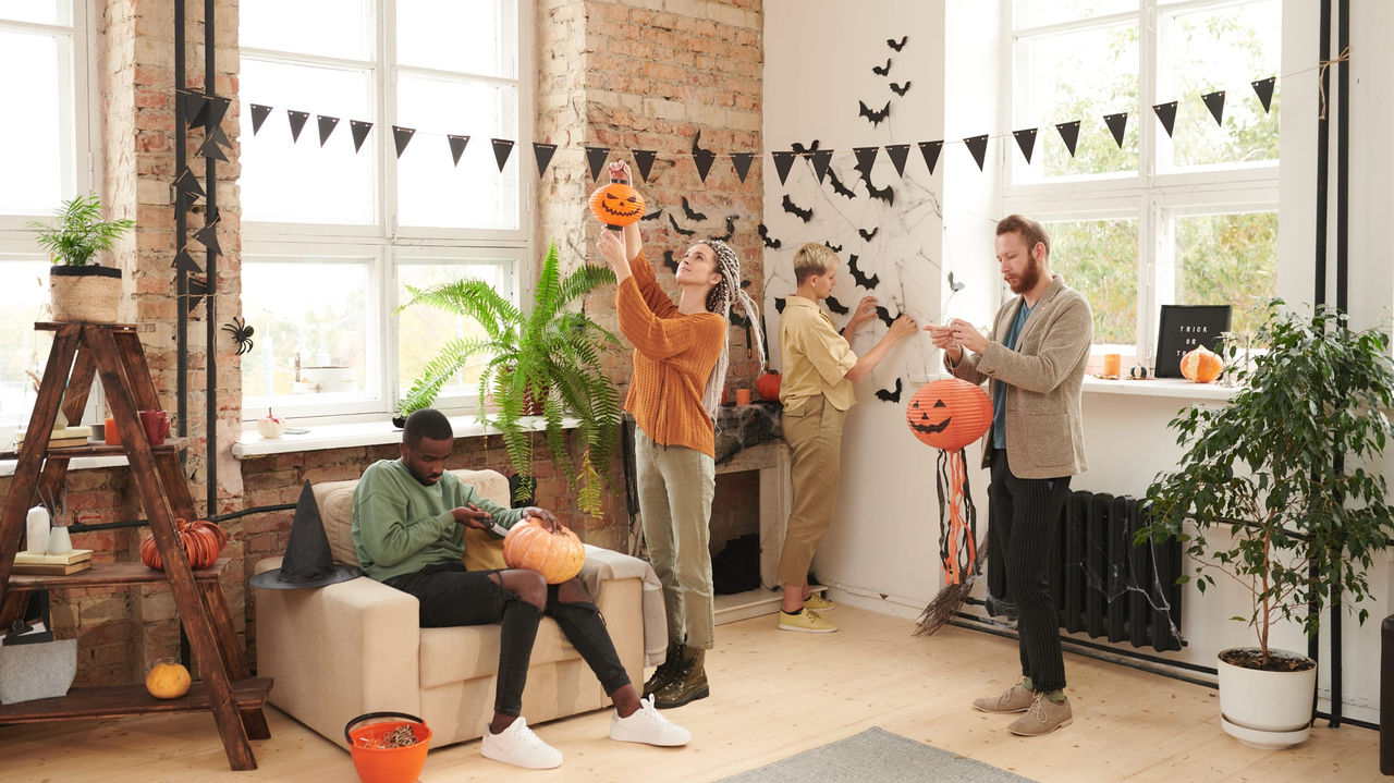 A group of people in a living room with halloween decorations.