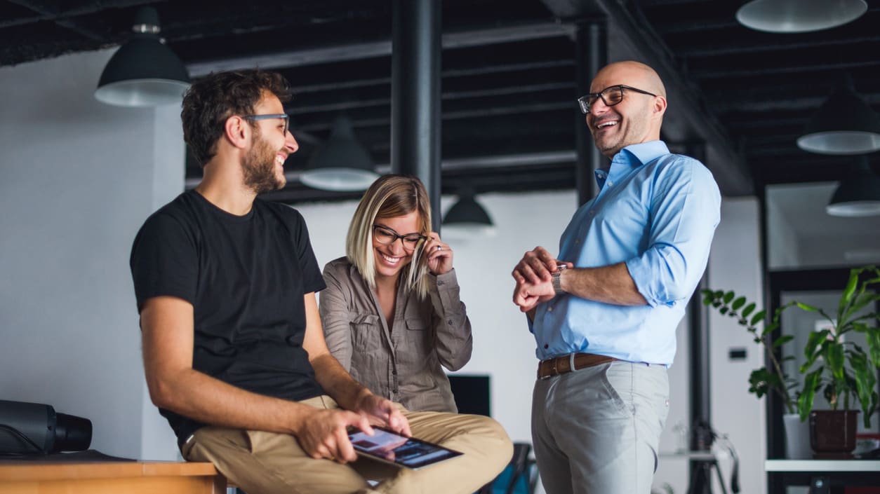 Three business people talking in an office.