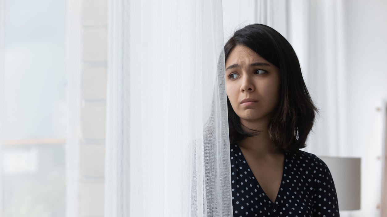 A young woman looking out of a window.