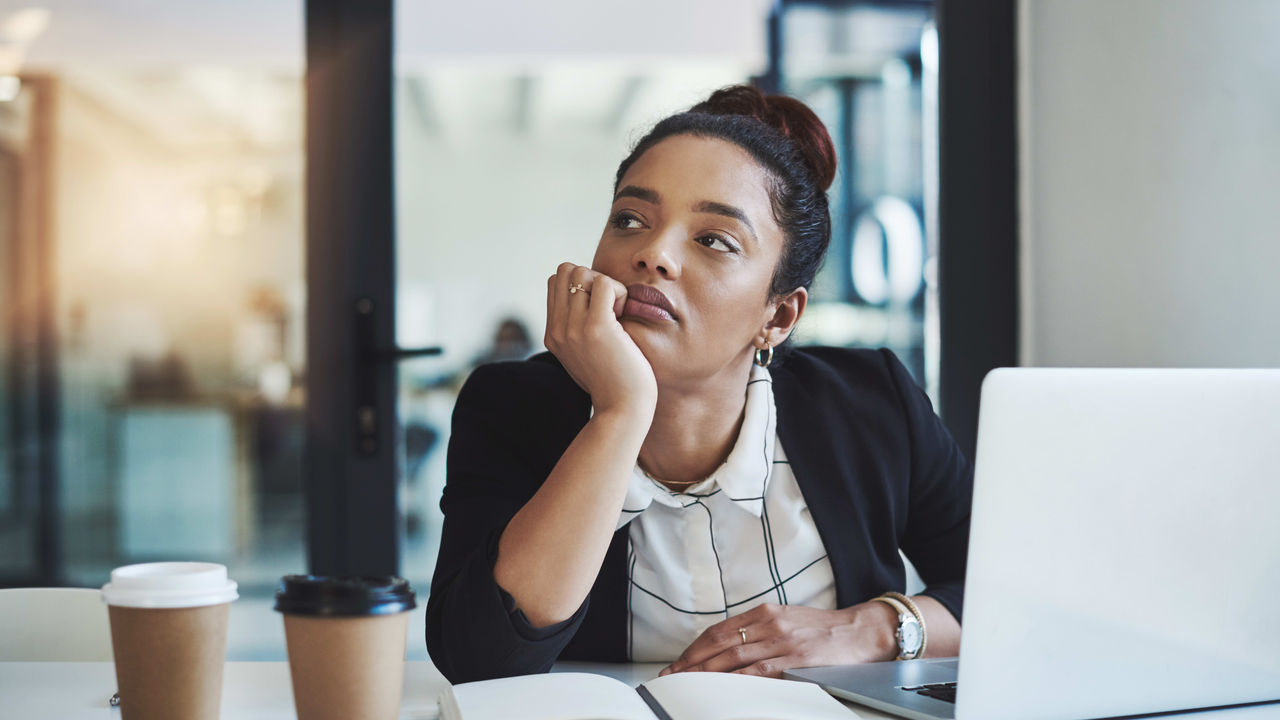 A woman sitting at a desk with a laptop in front of her.