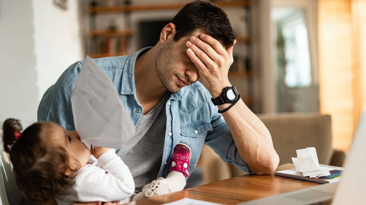 A man sitting at a desk with a child in front of him.