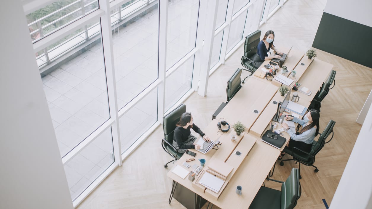 A group of people working at a desk in an office.