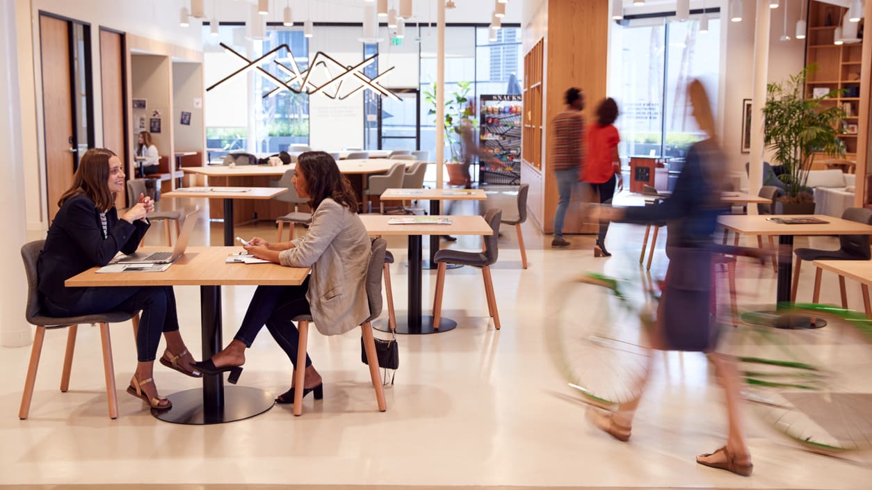 A group of people sitting at tables in an office.