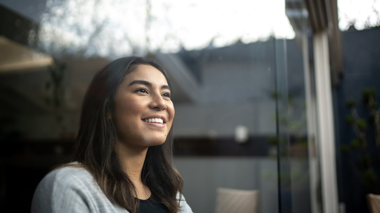 A young woman looking out of a window.