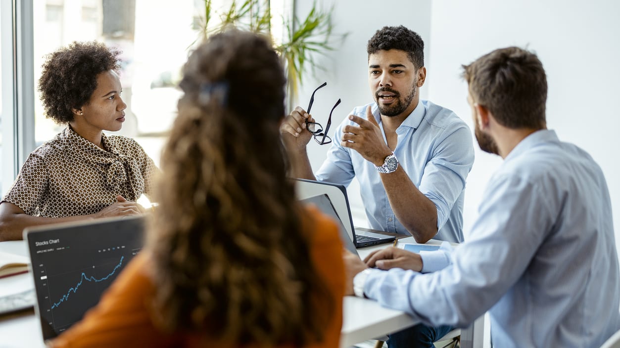 A group of people sitting around a table in an office.