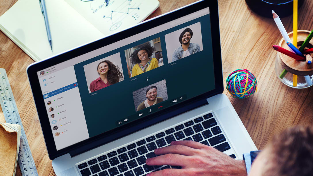 A man is using a laptop with a group of people on it.