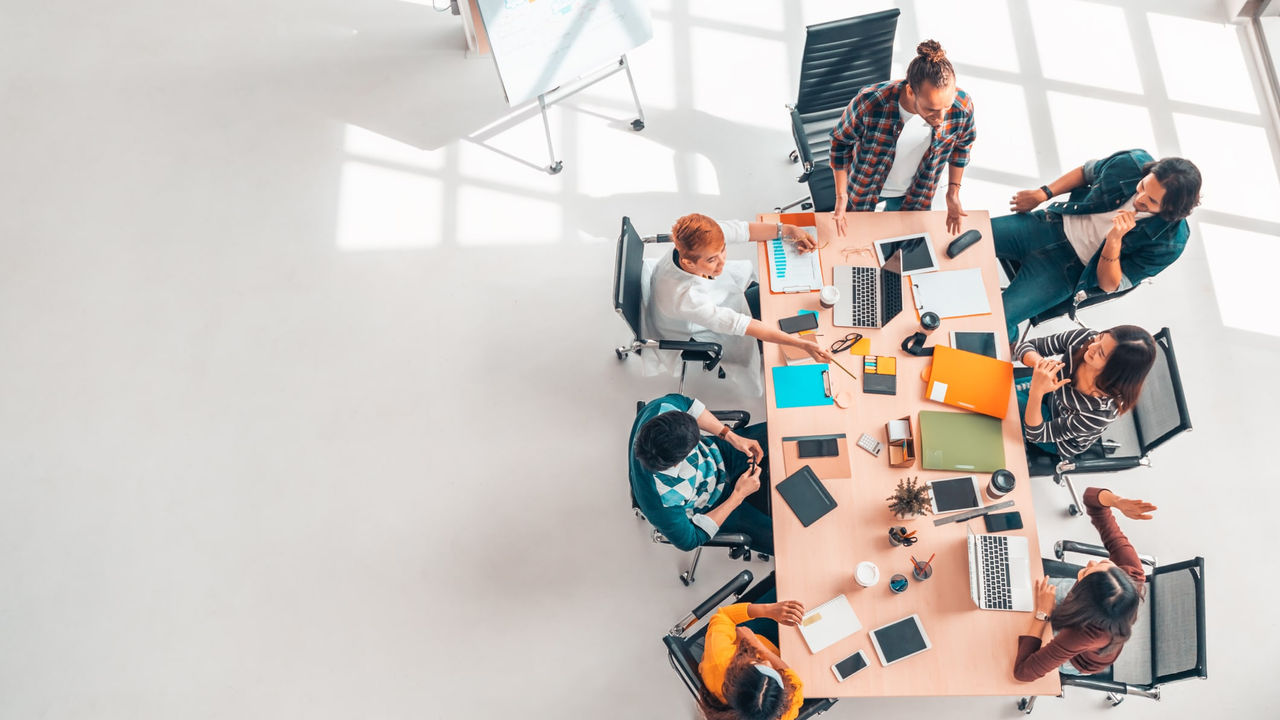 A group of people sitting around a table in an office.