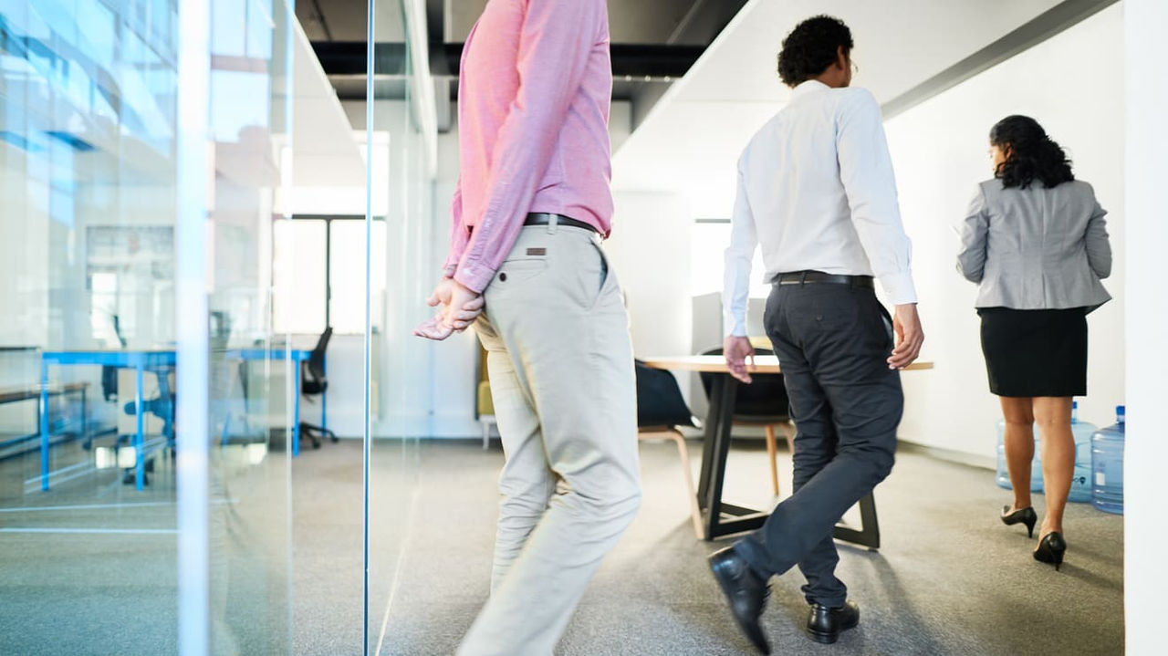 A group of business people walking in an office.