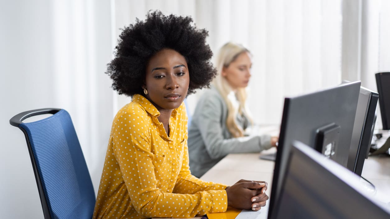 Two women working on computers in an office.