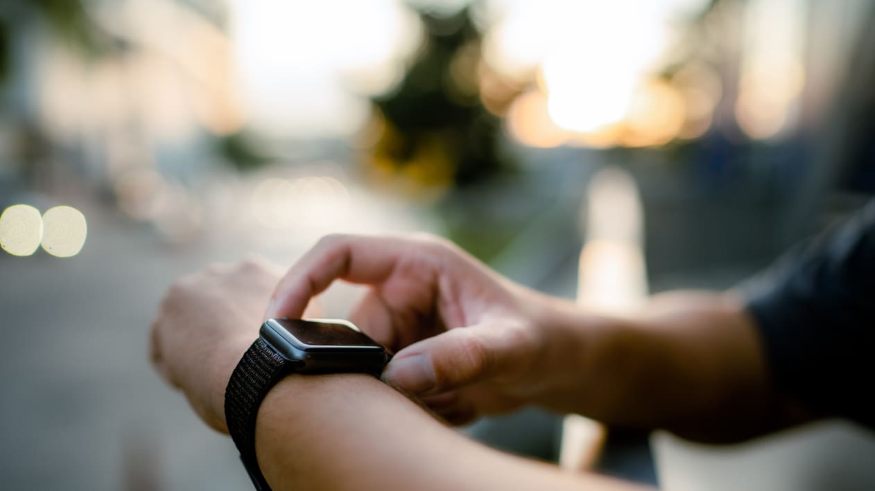 A man is holding an apple watch in his hand.