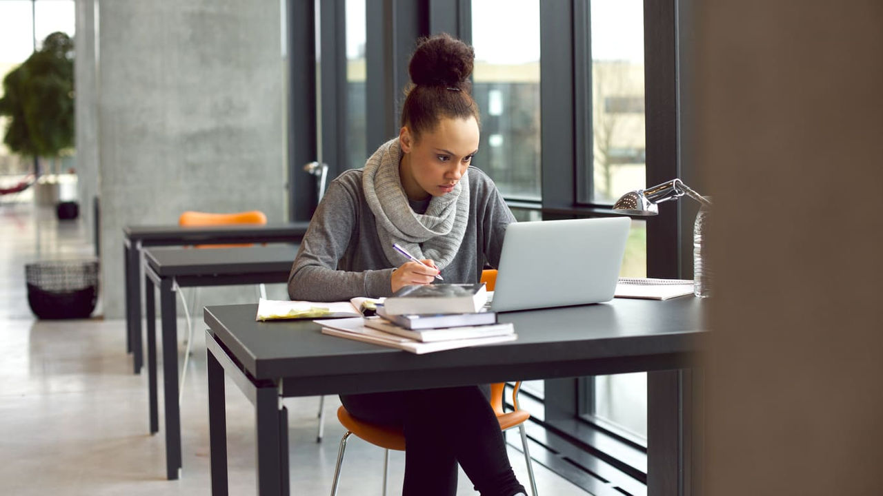 A woman sitting at a desk with a laptop.