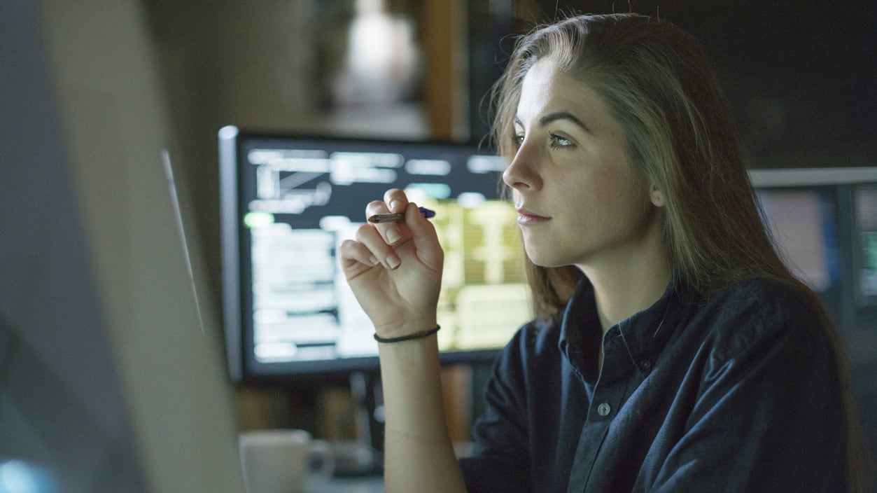 A woman sitting in front of a computer screen.