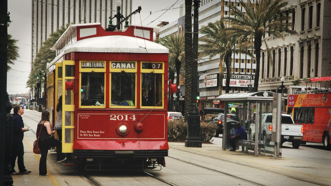 A red and yellow trolley car on a city street.