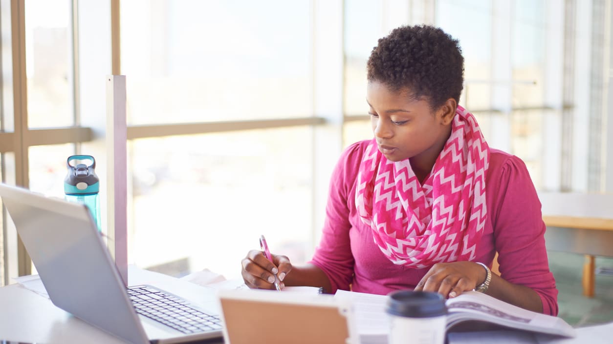 A young woman working on her laptop in an office.