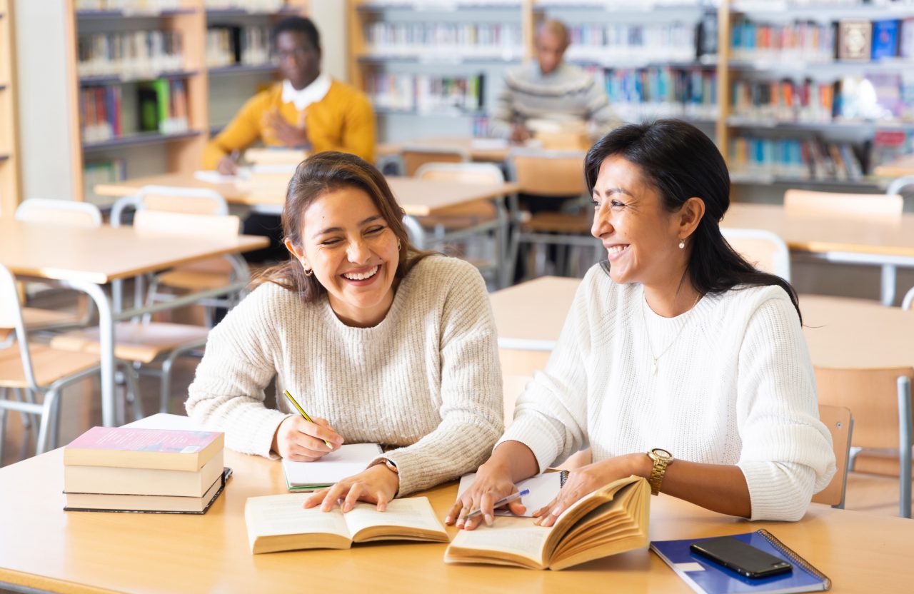 Two older students engage in their studies.