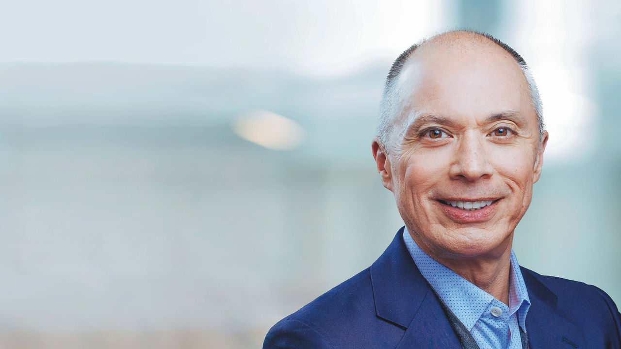 A man in a suit smiles for the camera.