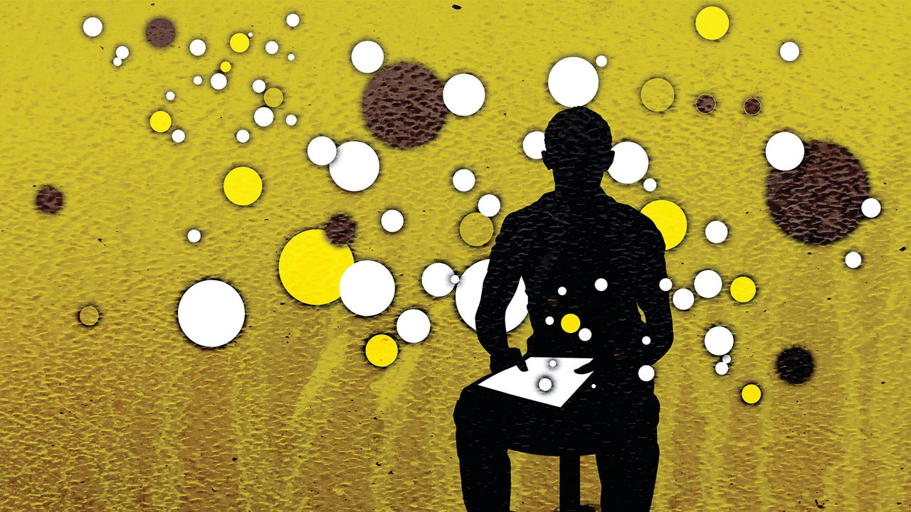 A silhouette of a man sitting on a chair with bubbles around him.