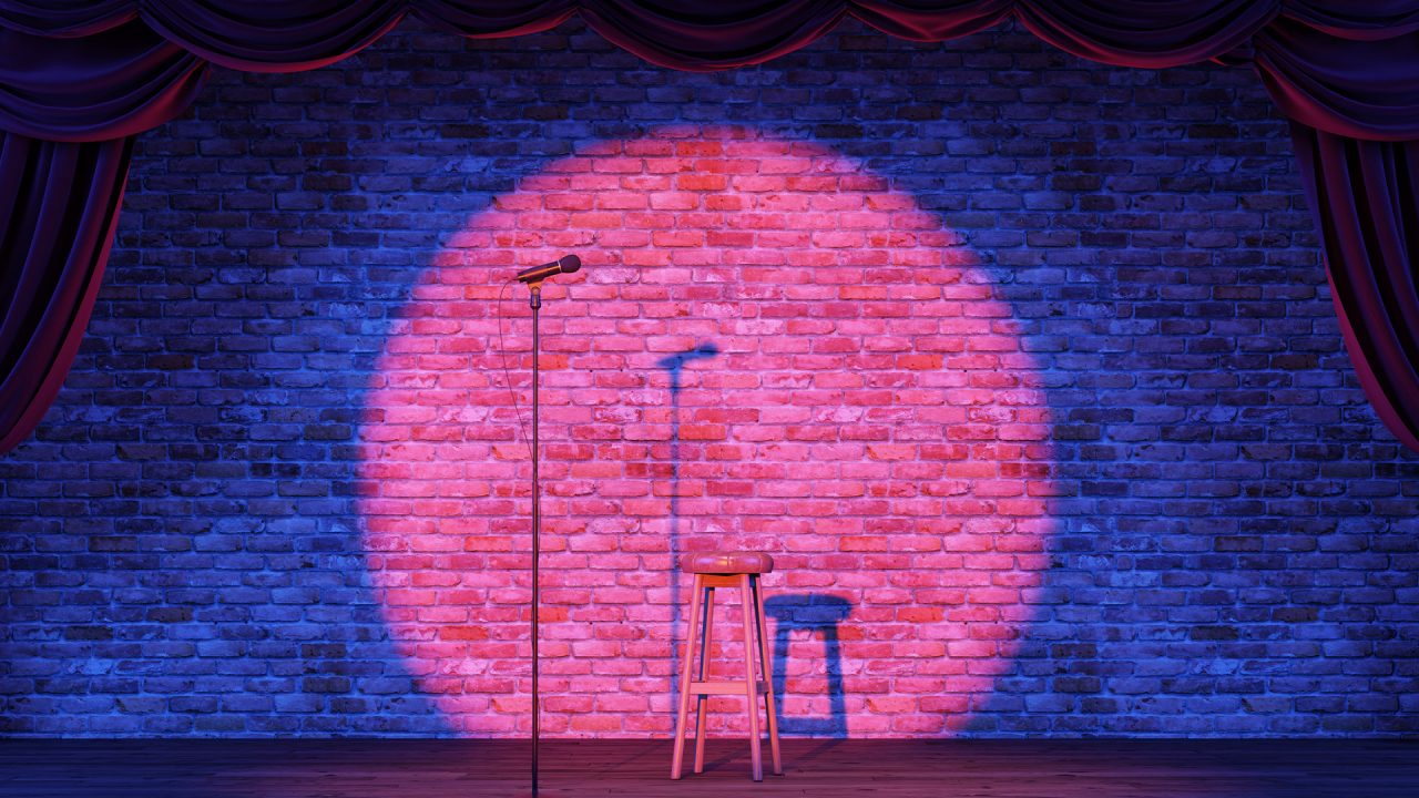 A stage and an open microphone under a spotlight. 