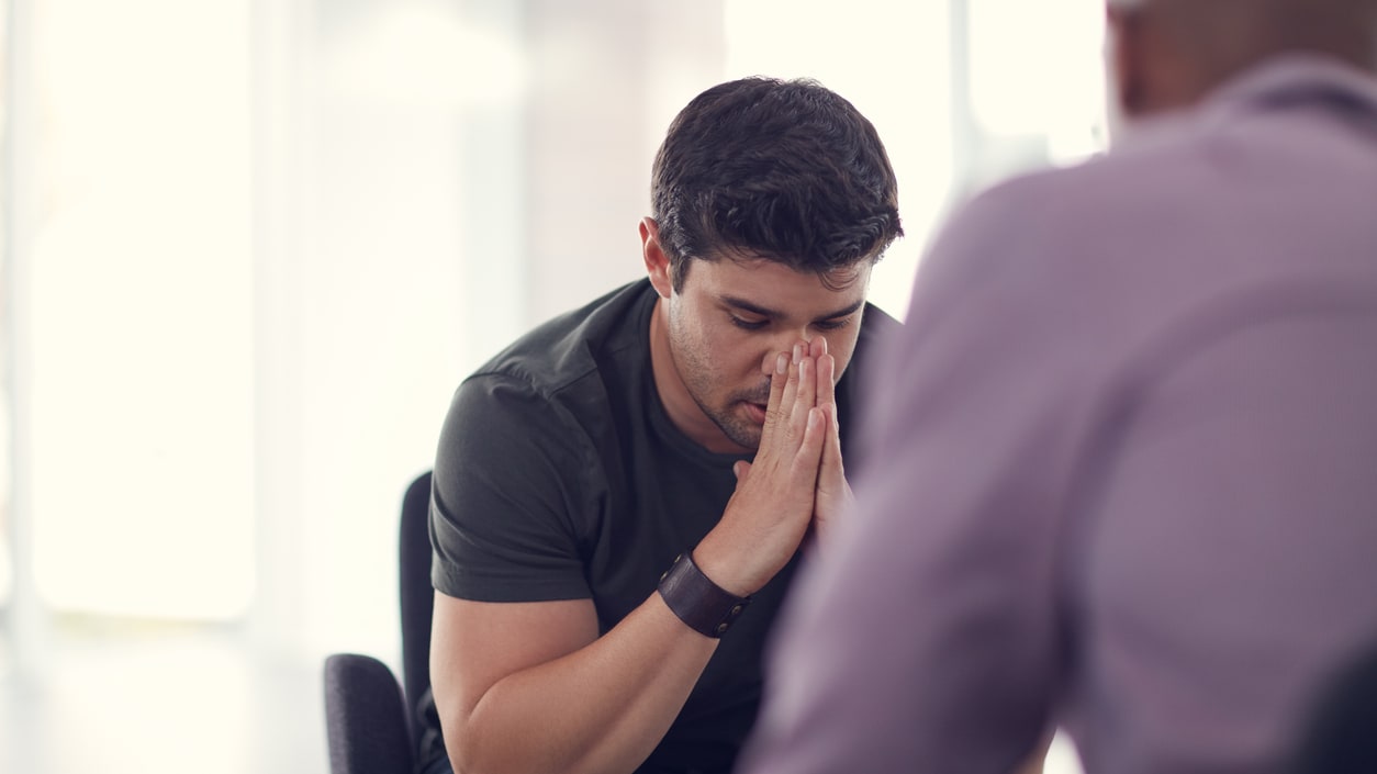 A man is talking to another man in an office.