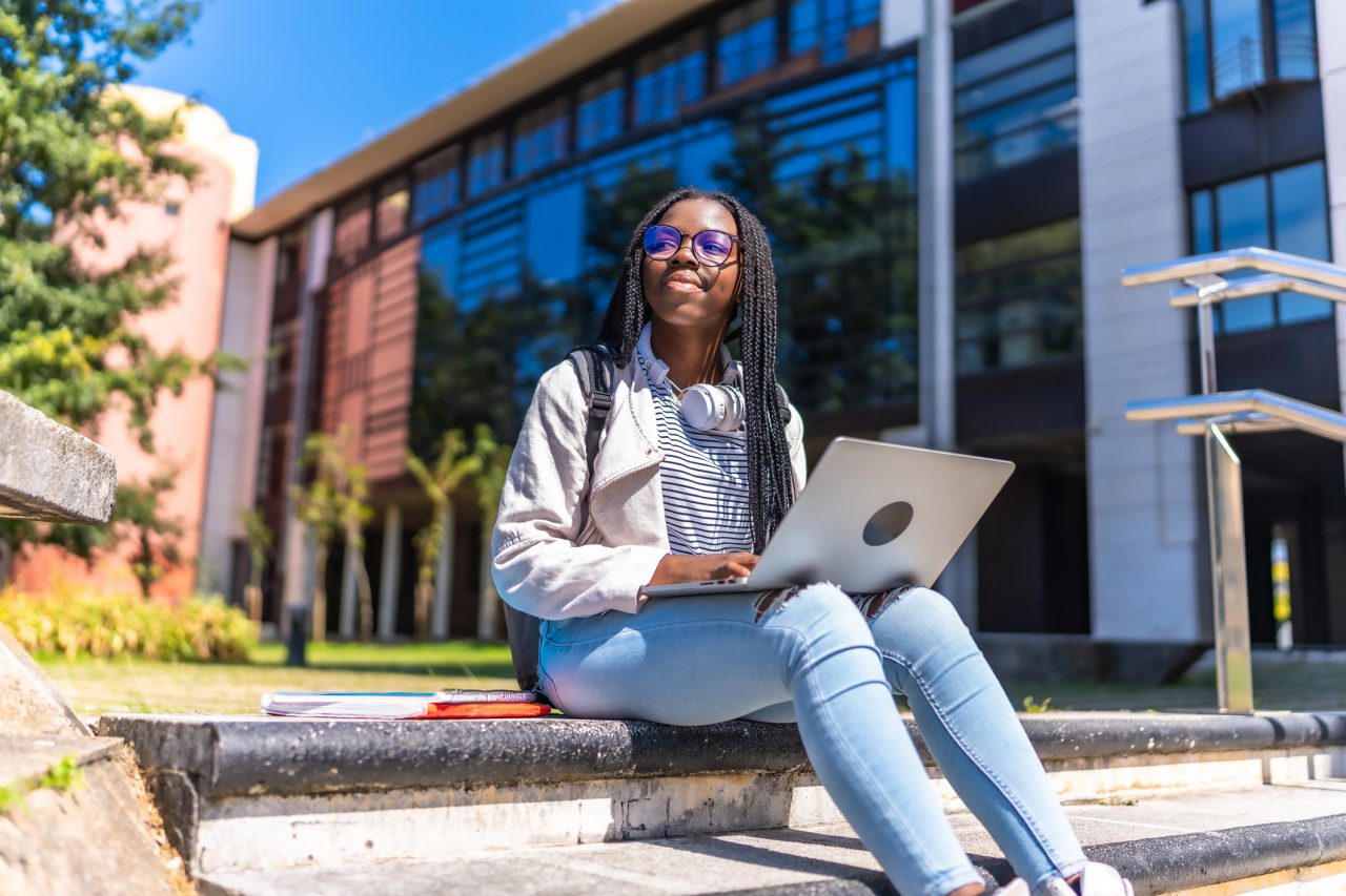 A student studying outdoors on a college campus