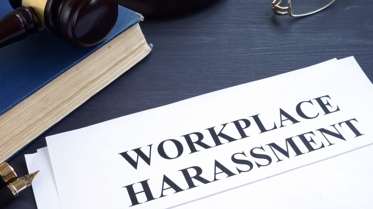 Workplace harassment on a table with a judge's gavel.