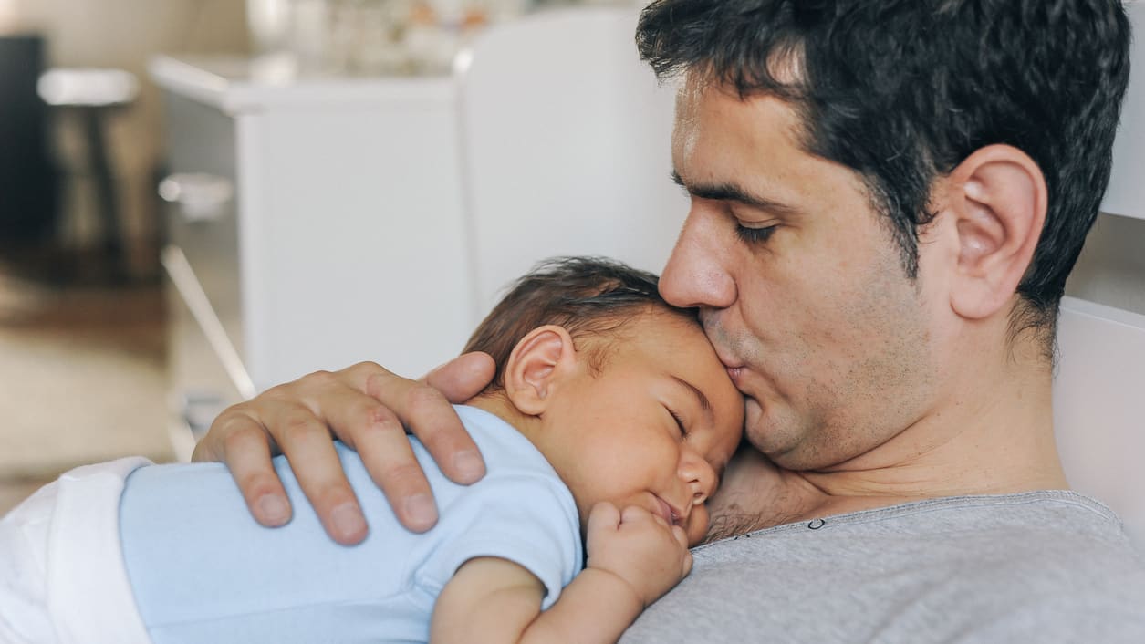 A man is holding a baby in his arms.