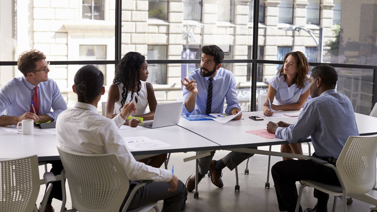 A group of people sitting around a table in a conference room.