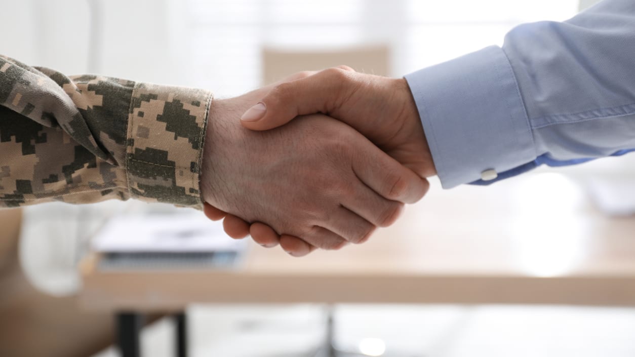 A man and a woman shaking hands in an office.