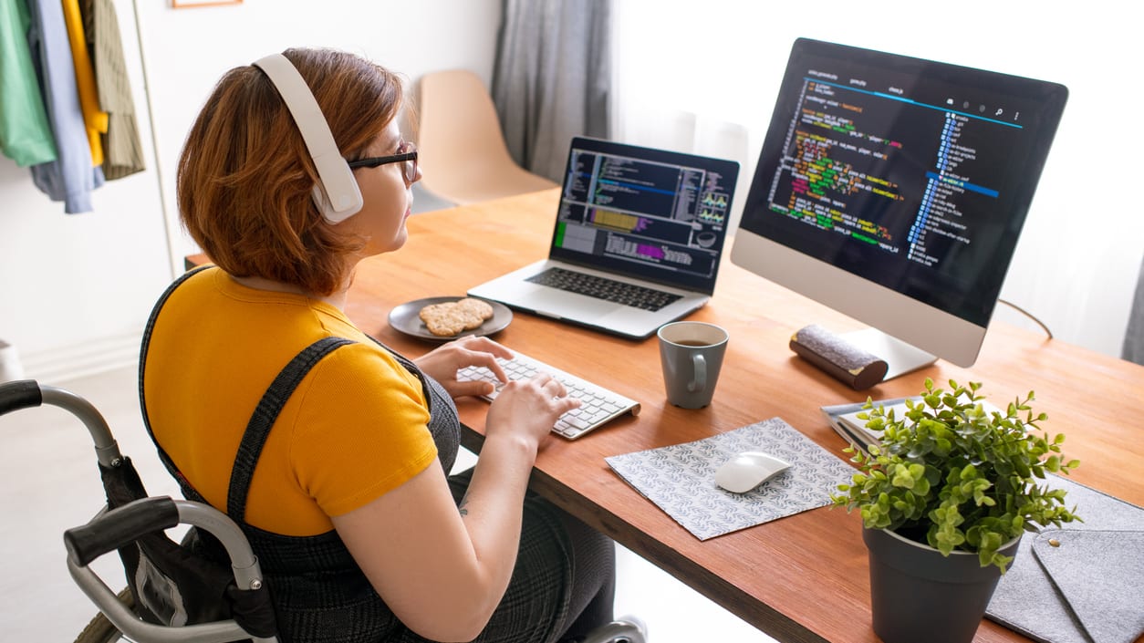 A woman in a wheelchair working on a computer.