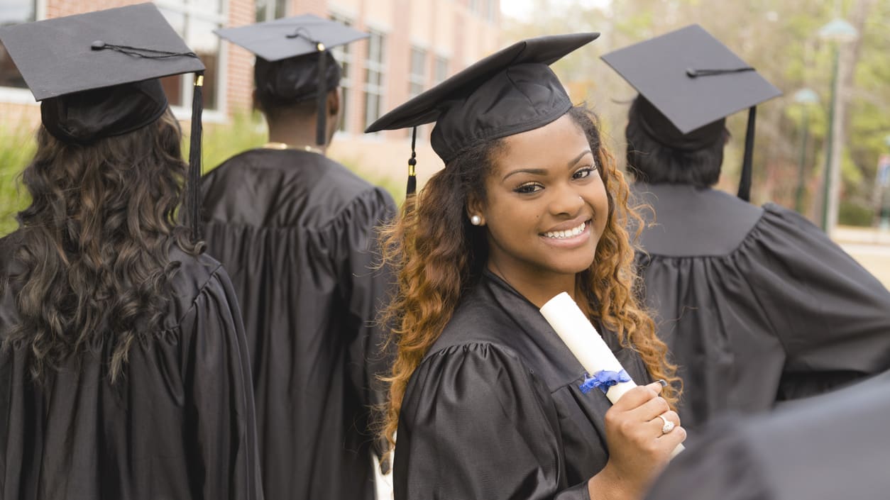 A group of women in graduation gowns and diplomas.