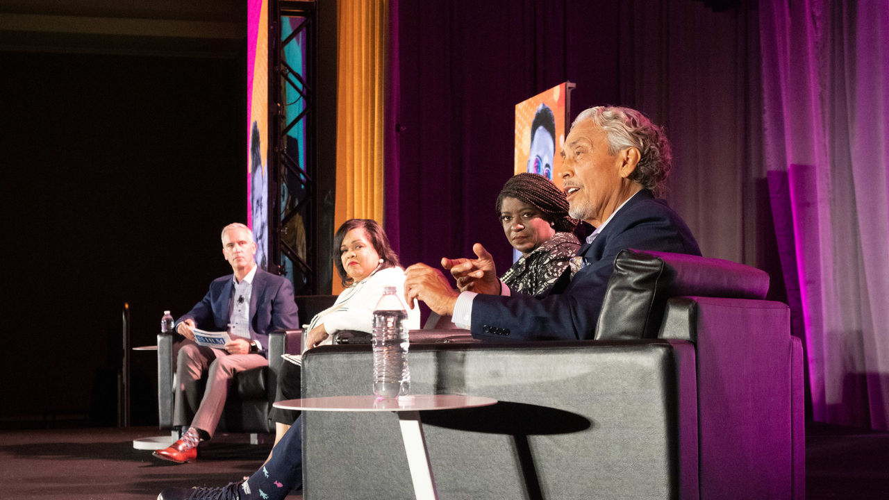 A group of people sitting on chairs on a stage.