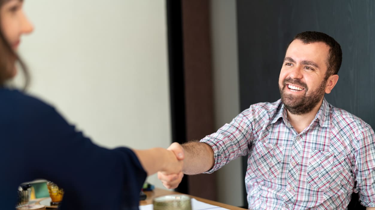 A man shaking hands with a woman in an office.