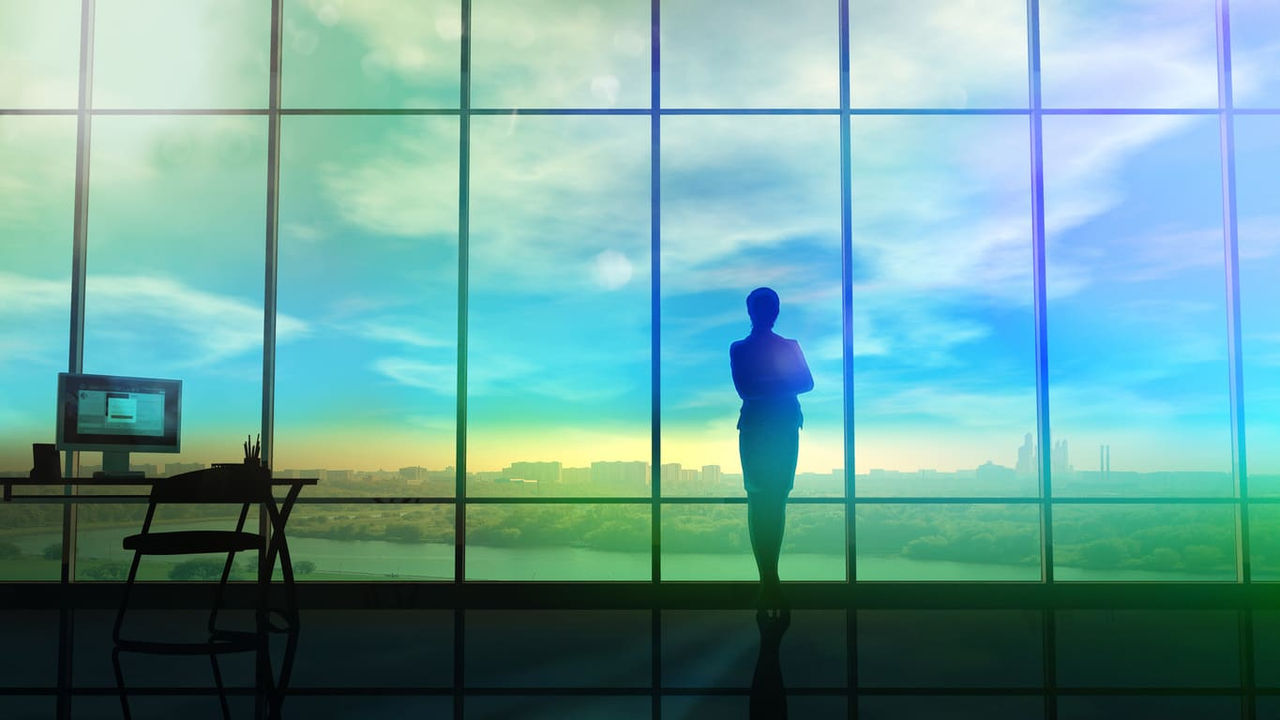A silhouette of a man standing in front of a window.