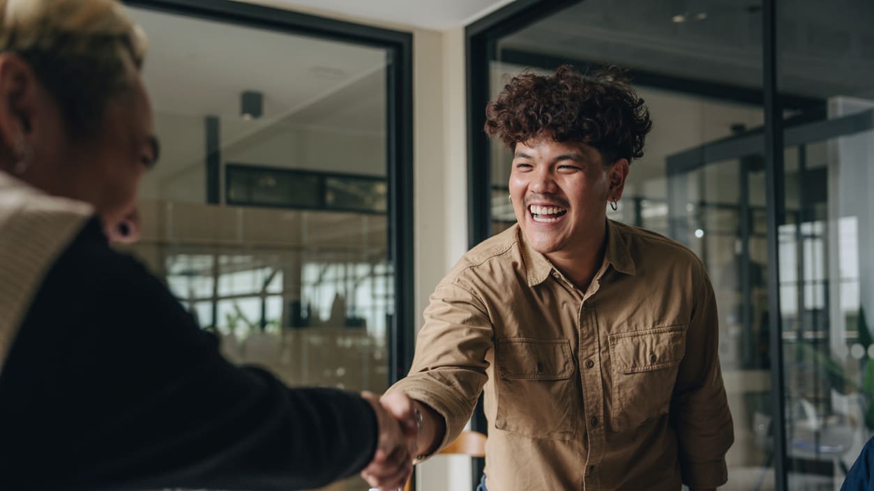 A group of people shaking hands in an office.