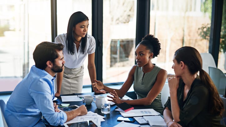 A group of business people sitting around a table.
