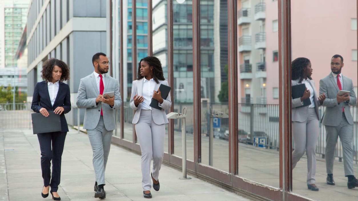 A group of business people walking in front of a building.
